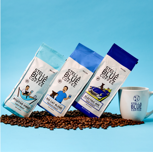 Three bags of stella blue whole bean coffee with a coffee cup