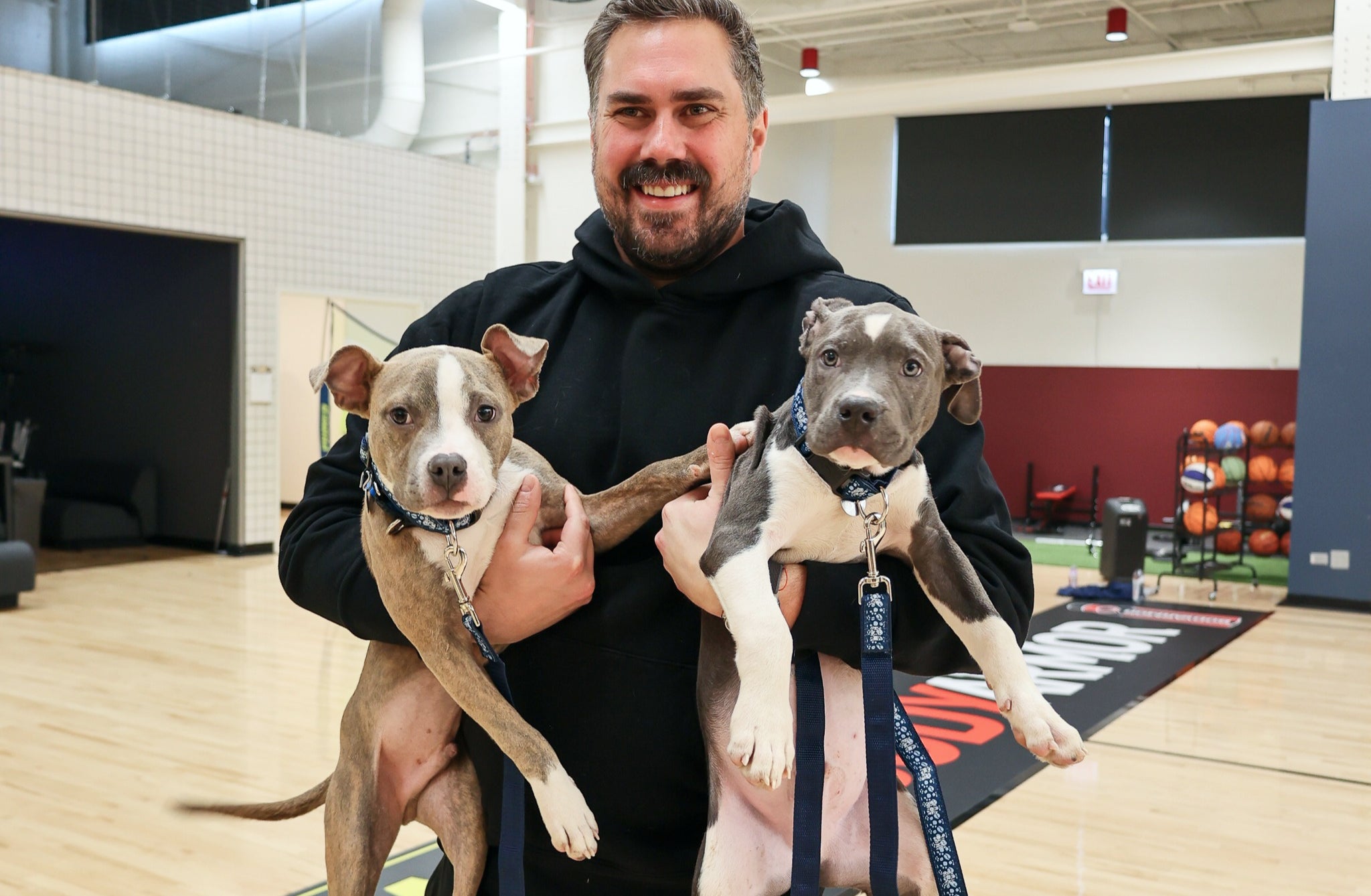 Dan Big Cat Katz holding two puppies